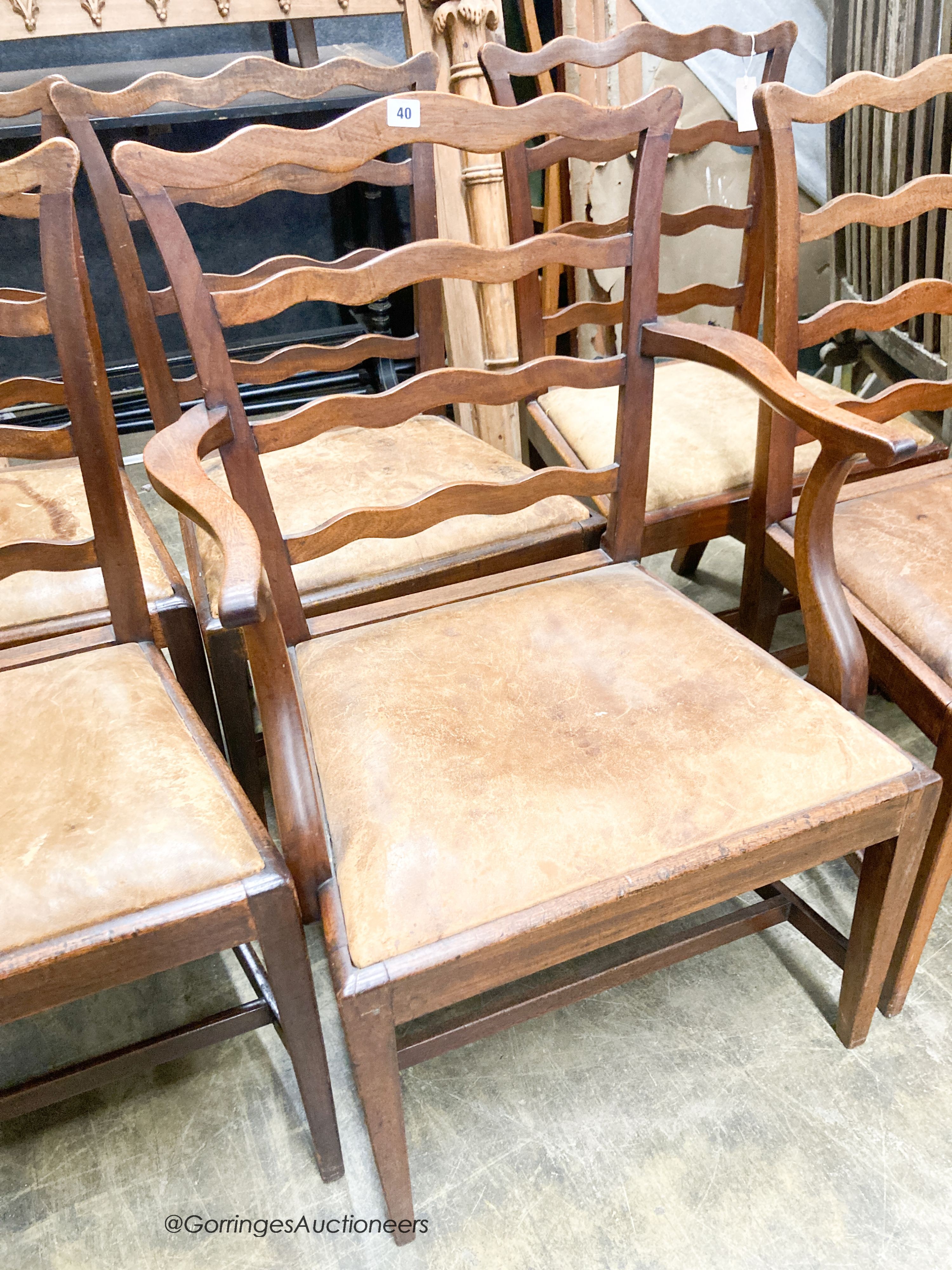 A set of six George III mahogany ladderback dining chairs with leather drop in seats (one with arms)